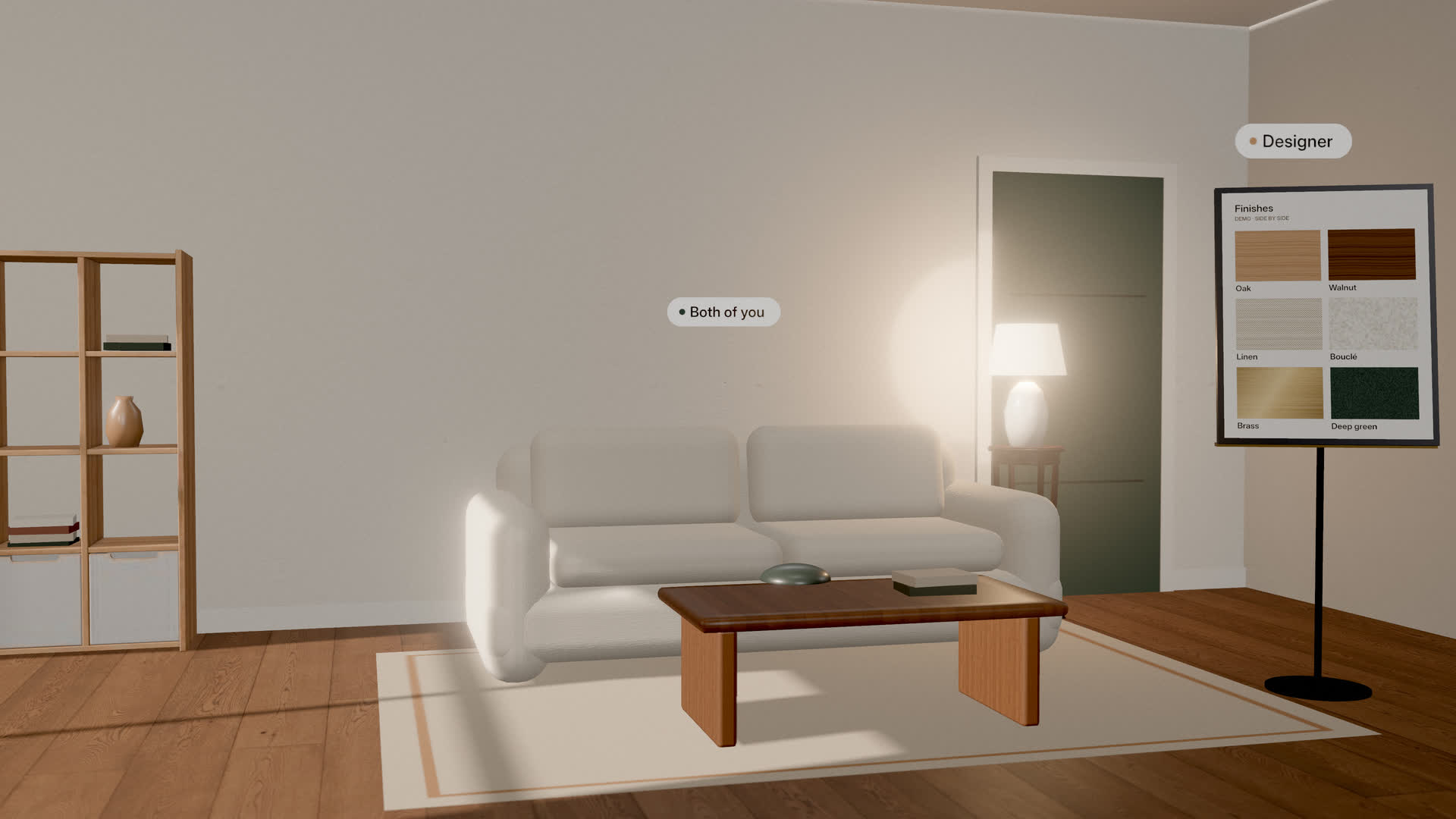 Demo living room: a white sofa, a wooden coffee table and open shelving at true size, with a finishes board of oak, walnut, linen, bouclé, brass and deep green; Designer and Both of you are in the room.